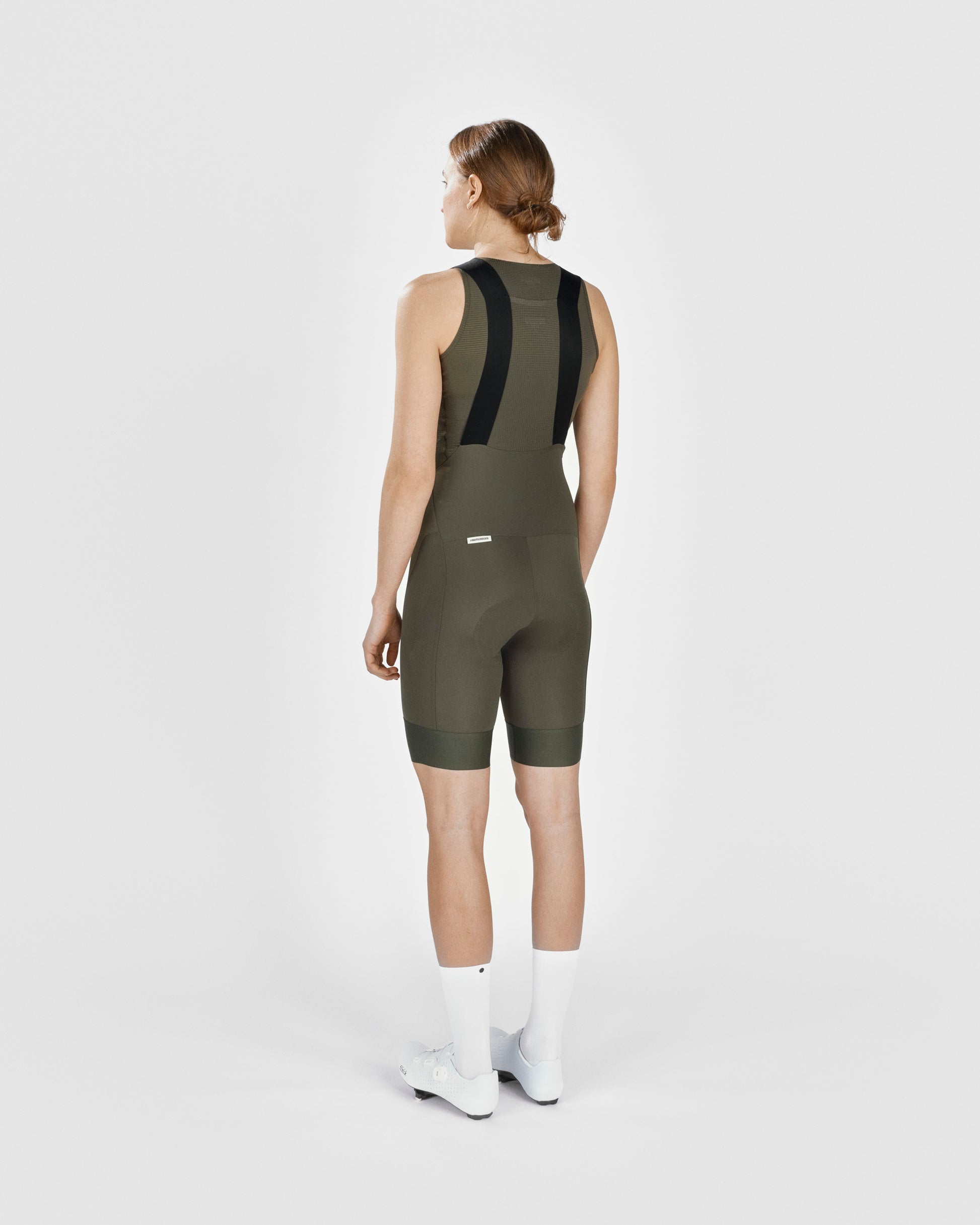 A female cyclist showing the back of a Fingerscrossed #Road cycling Bib Shorts in Olive