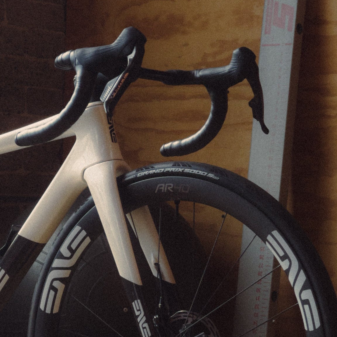An Enve Melee in Aspen White with Enve AR40 wheels in a plywood room