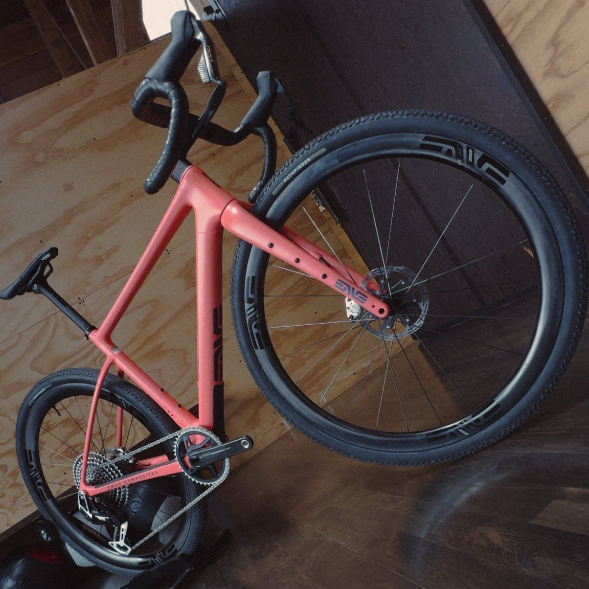 An Enve MOG gravel bike in Wayfinder coral in a wood room