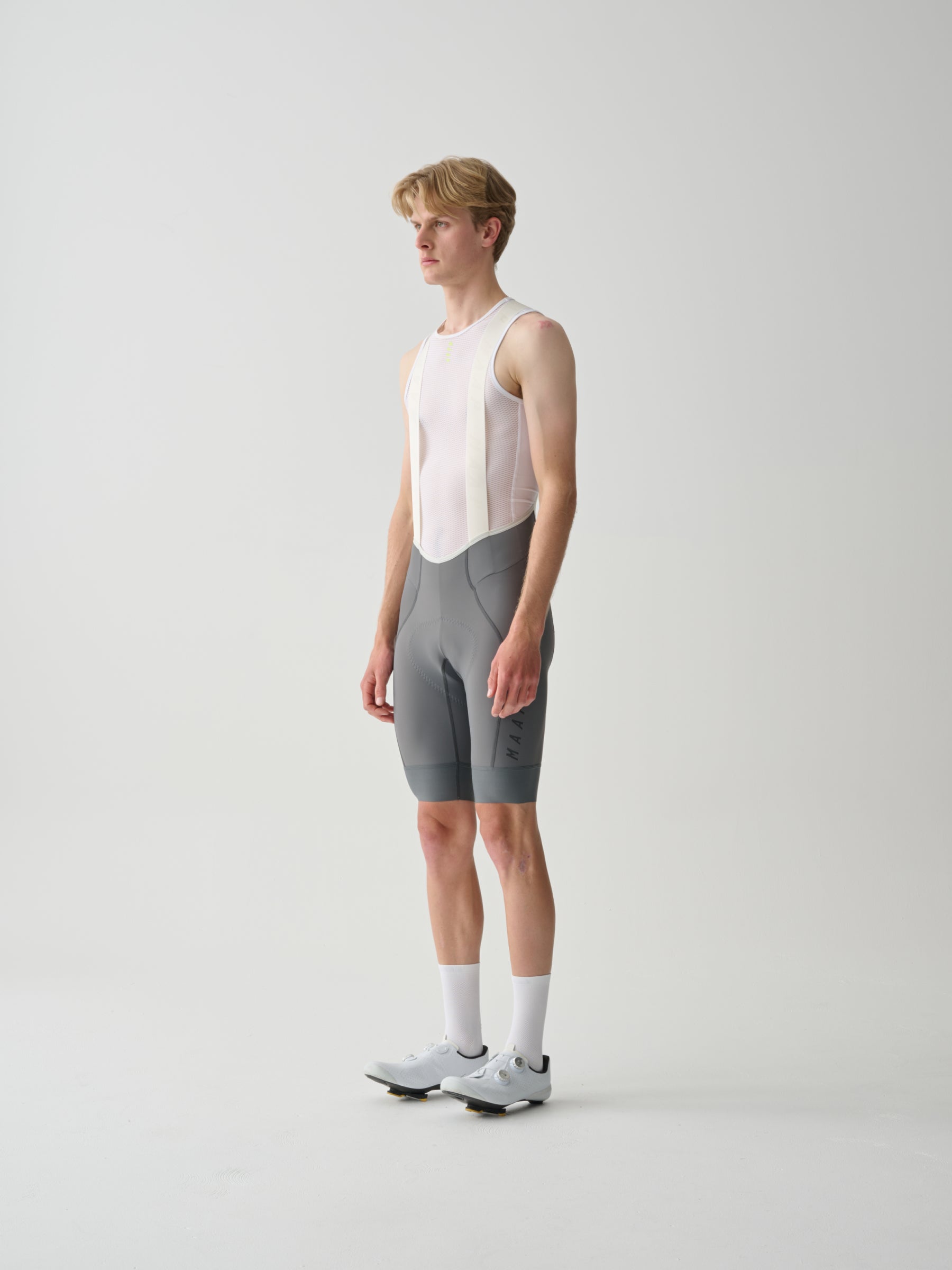 A male model wearing gray MAAP Team Bib Evo cycling bib shorts