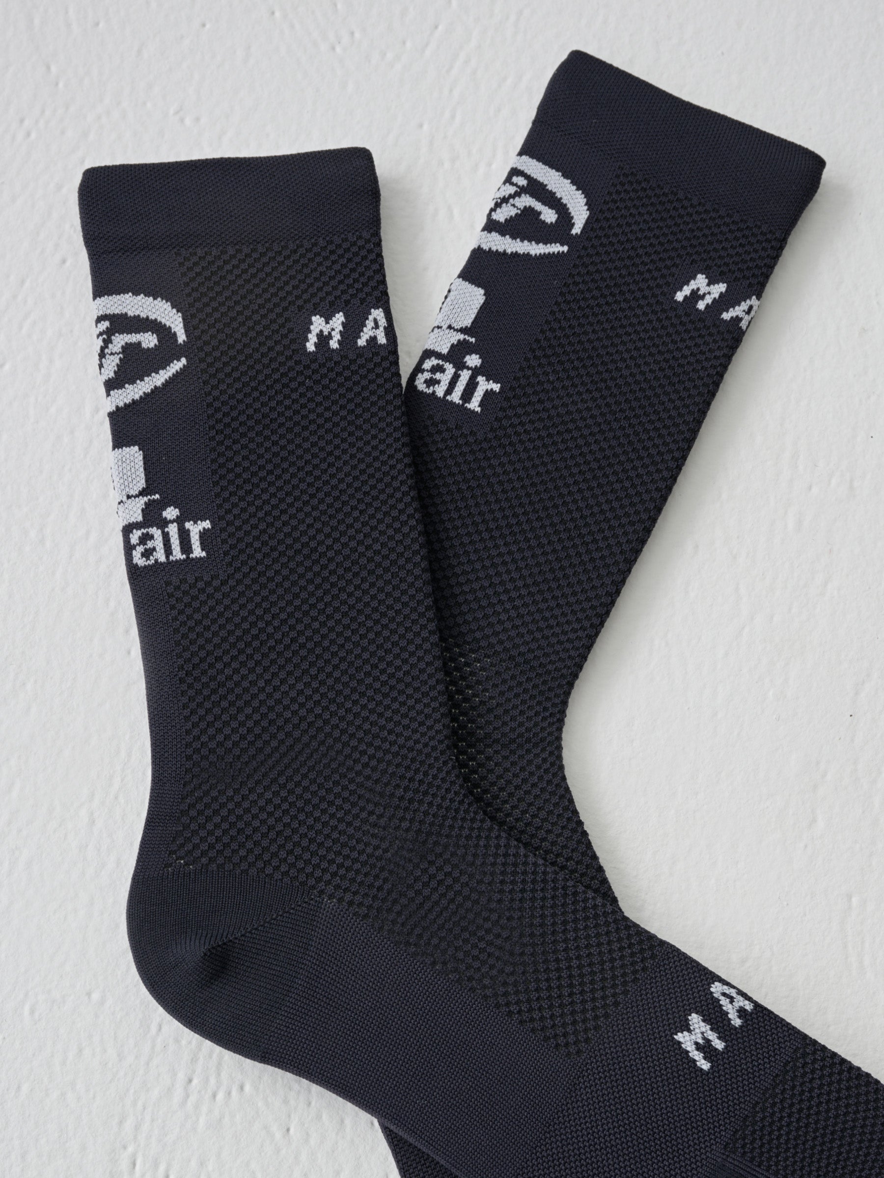 A close up of the air logos on a pair of MAAP Aether socks in Black