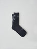 A flat lay image of MAAPs Aether sock in Black