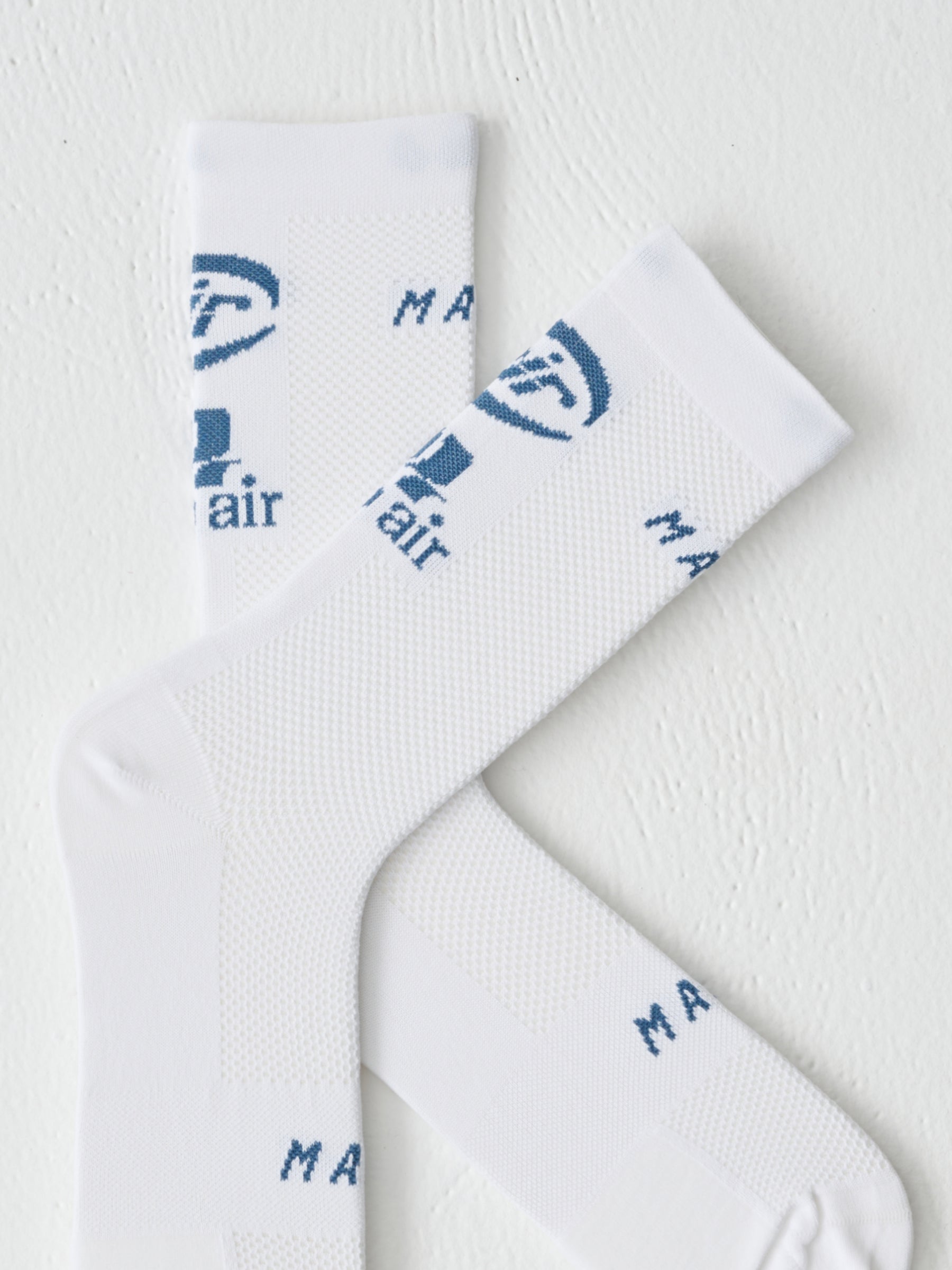 A detail image of the air logos on the MAAP Aether sock in White
