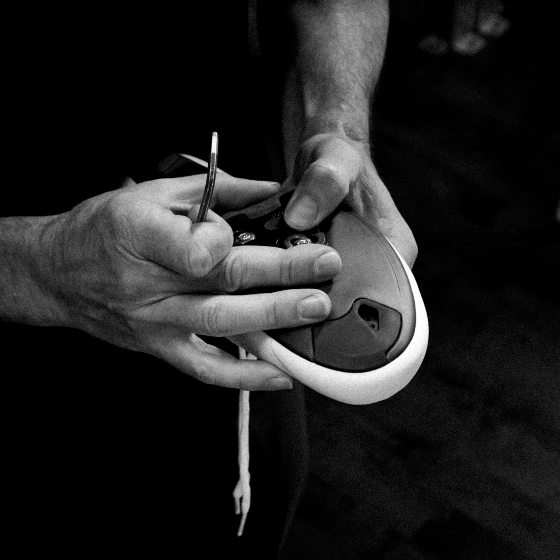 A Bike Fitter at Metier tightening adjusting the cleat on a road cycling shoe.