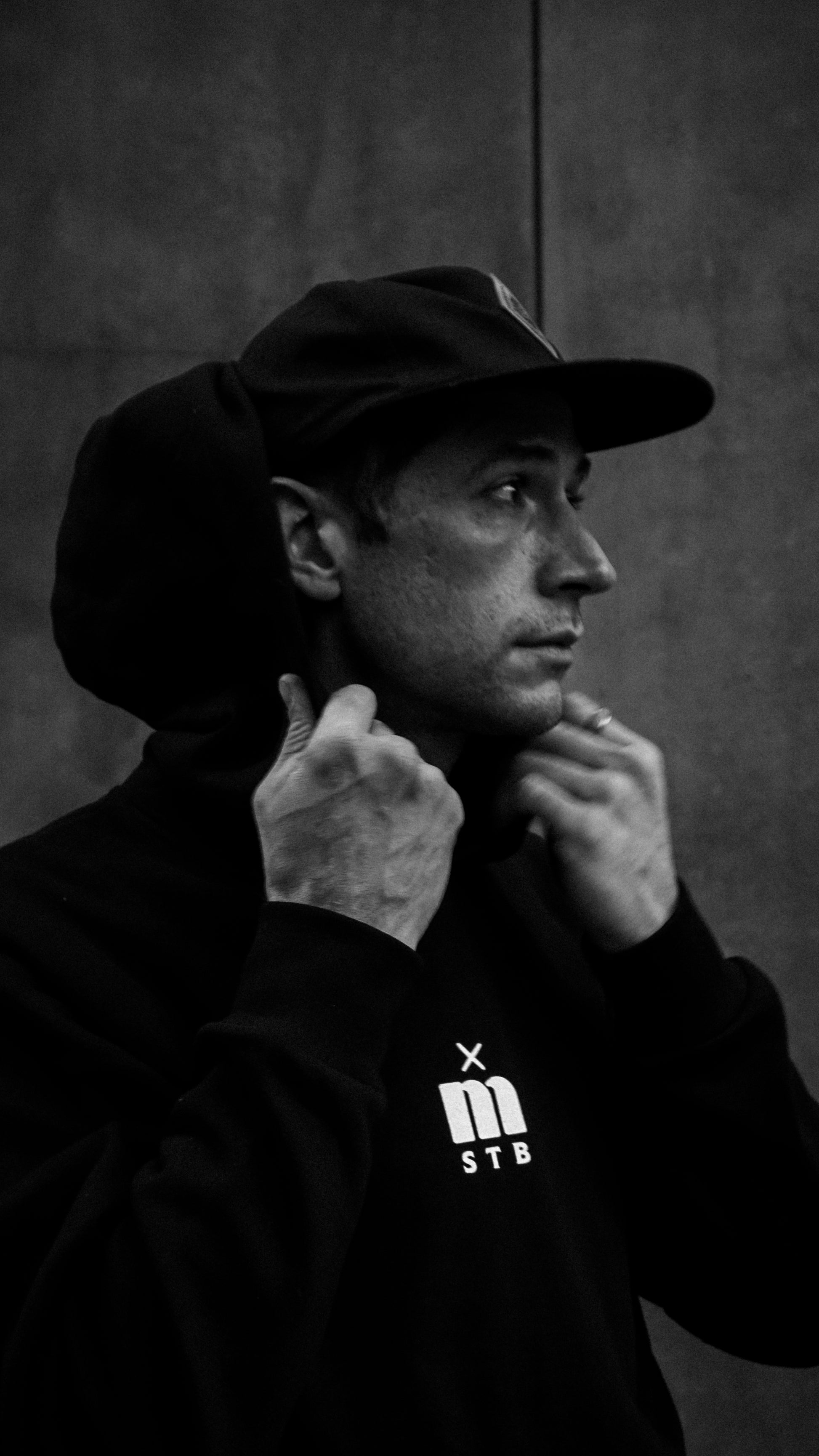 Closeup of a man wearing a Métier STB Stab The Beast Hoodie in Black