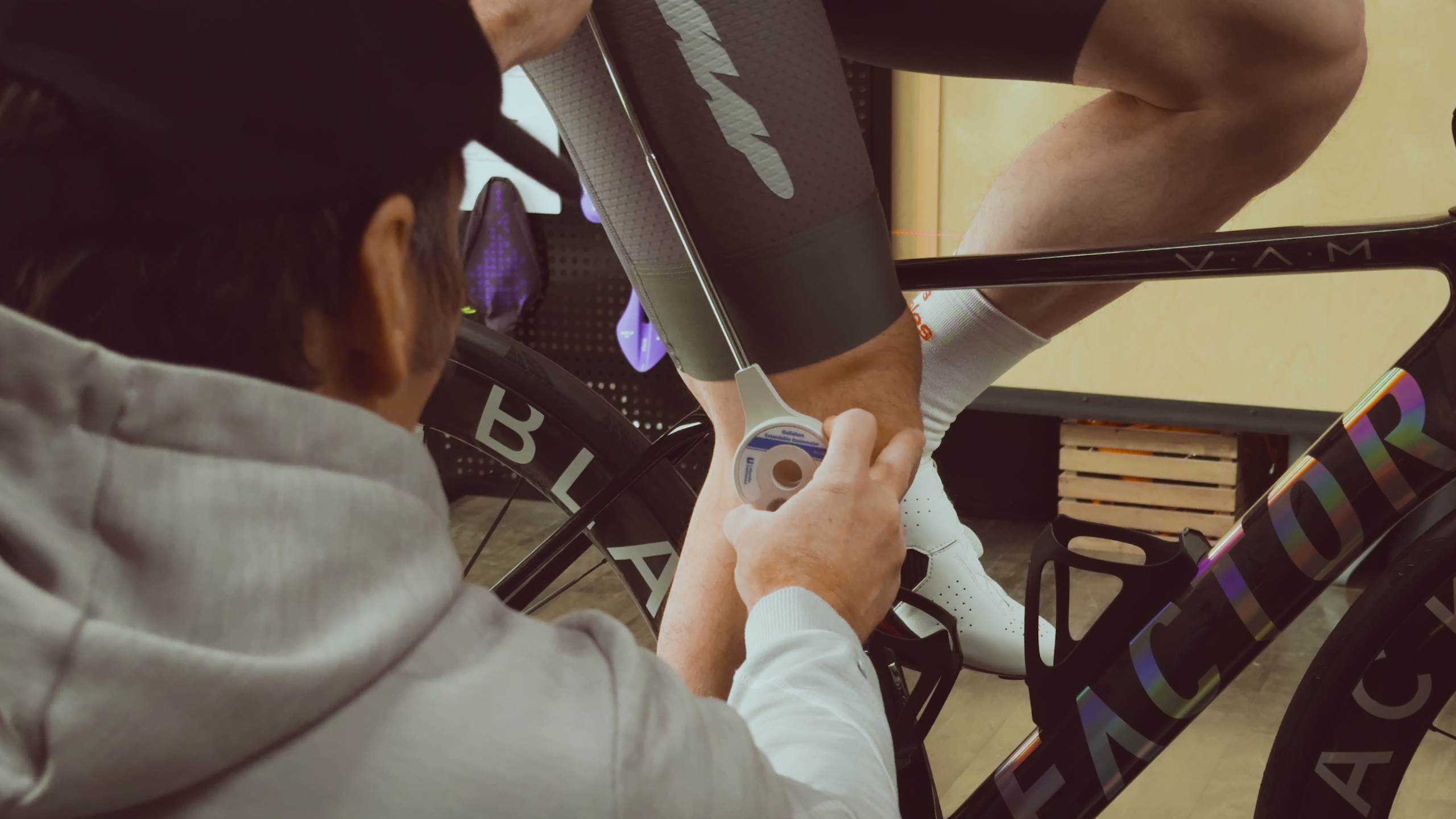 A Bike Fitter from Metier using a goniometer to measure the knee angle of a cyclist during a bike fit