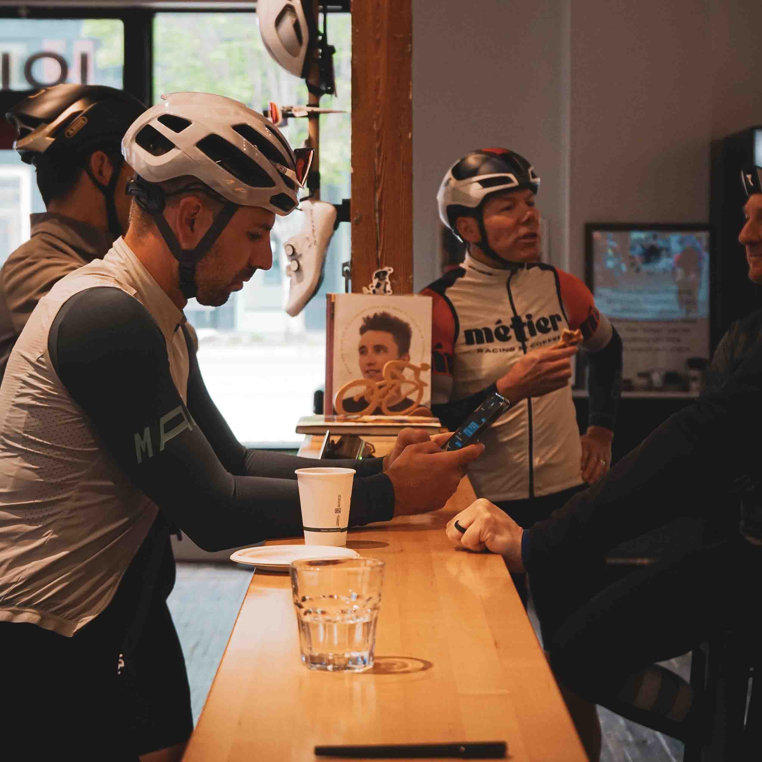 A group of road cyclists chatting in the cafe at Metier prior to departing on a Seattle group ride.