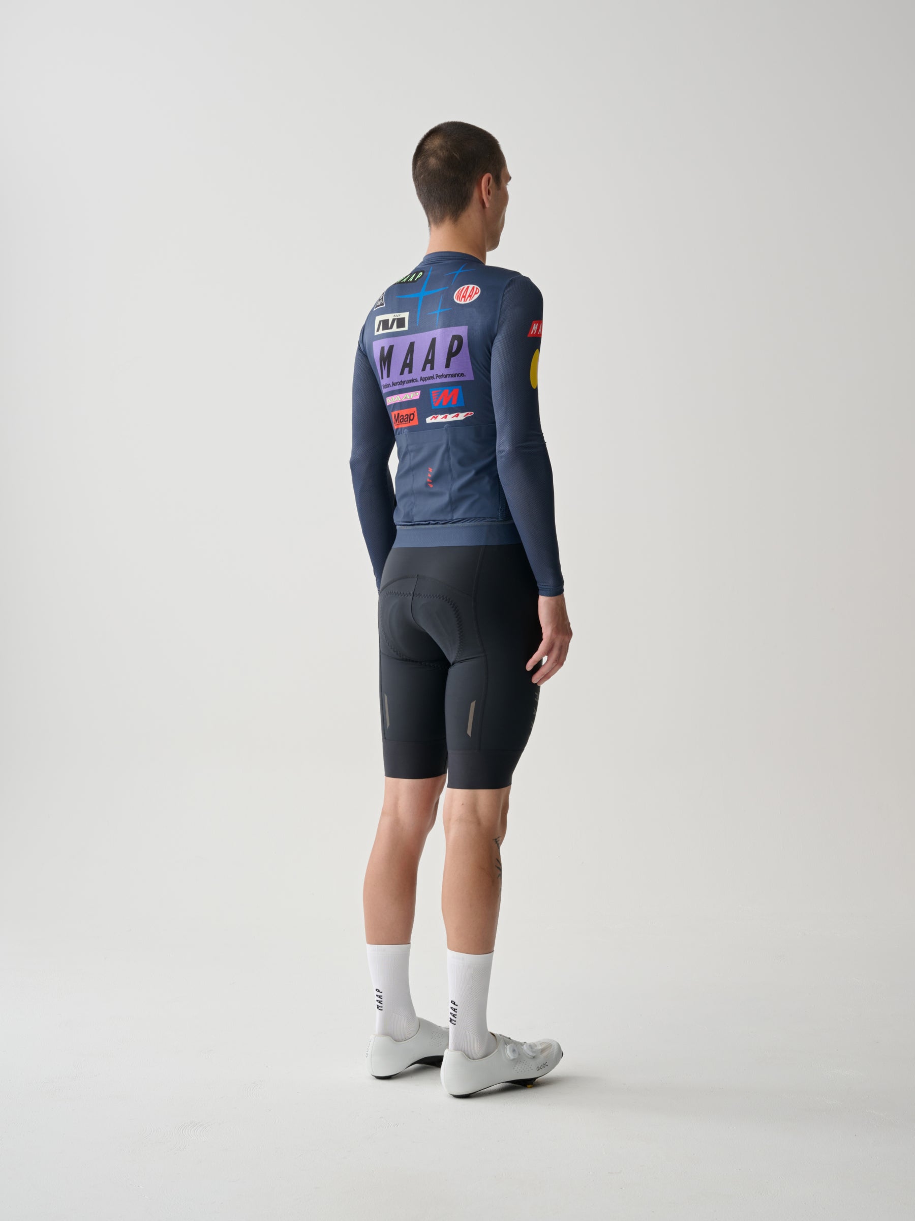 A male cyclist showing the back of a Men's MAAP Drome Long Sleeve Jersey in Midnight Blue