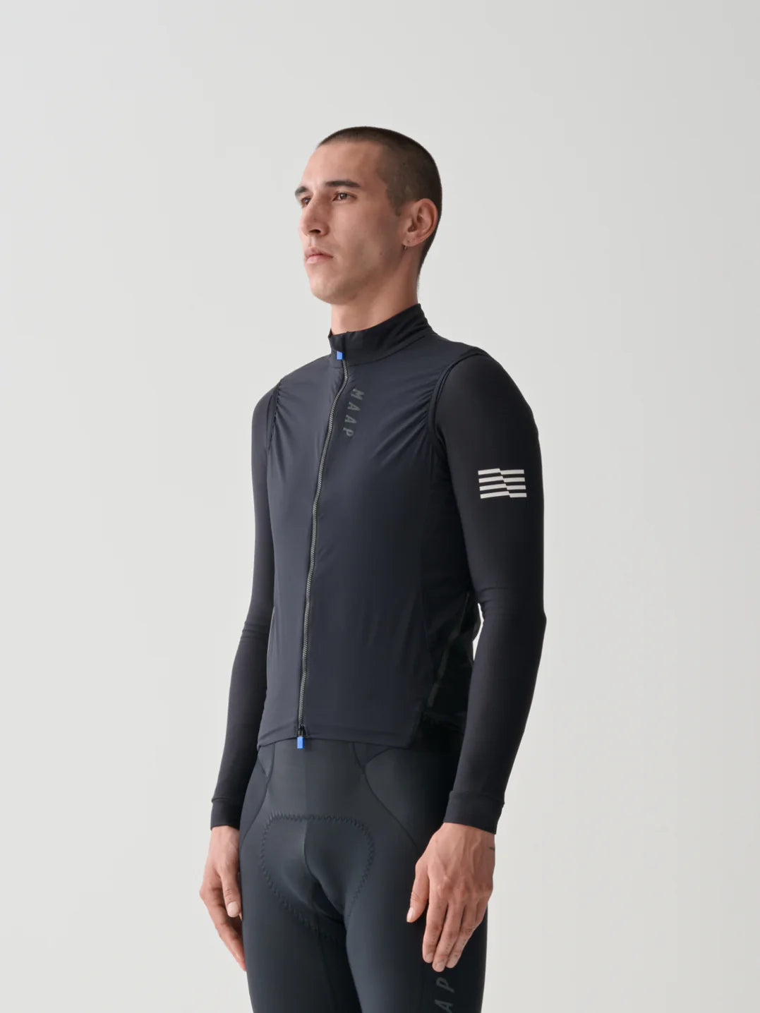 The upper half of a male cyclist wearing the MAAP Flow Vest in Black with a white background