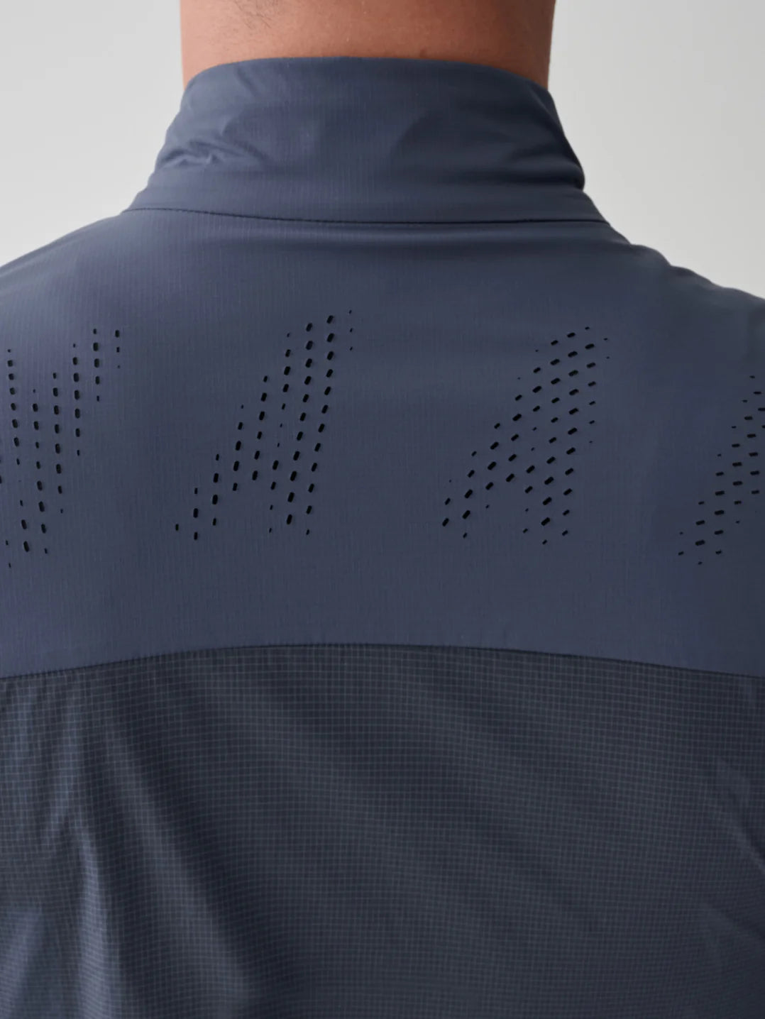 The perforated back panel of a MAAP Flow Vest in Midnight