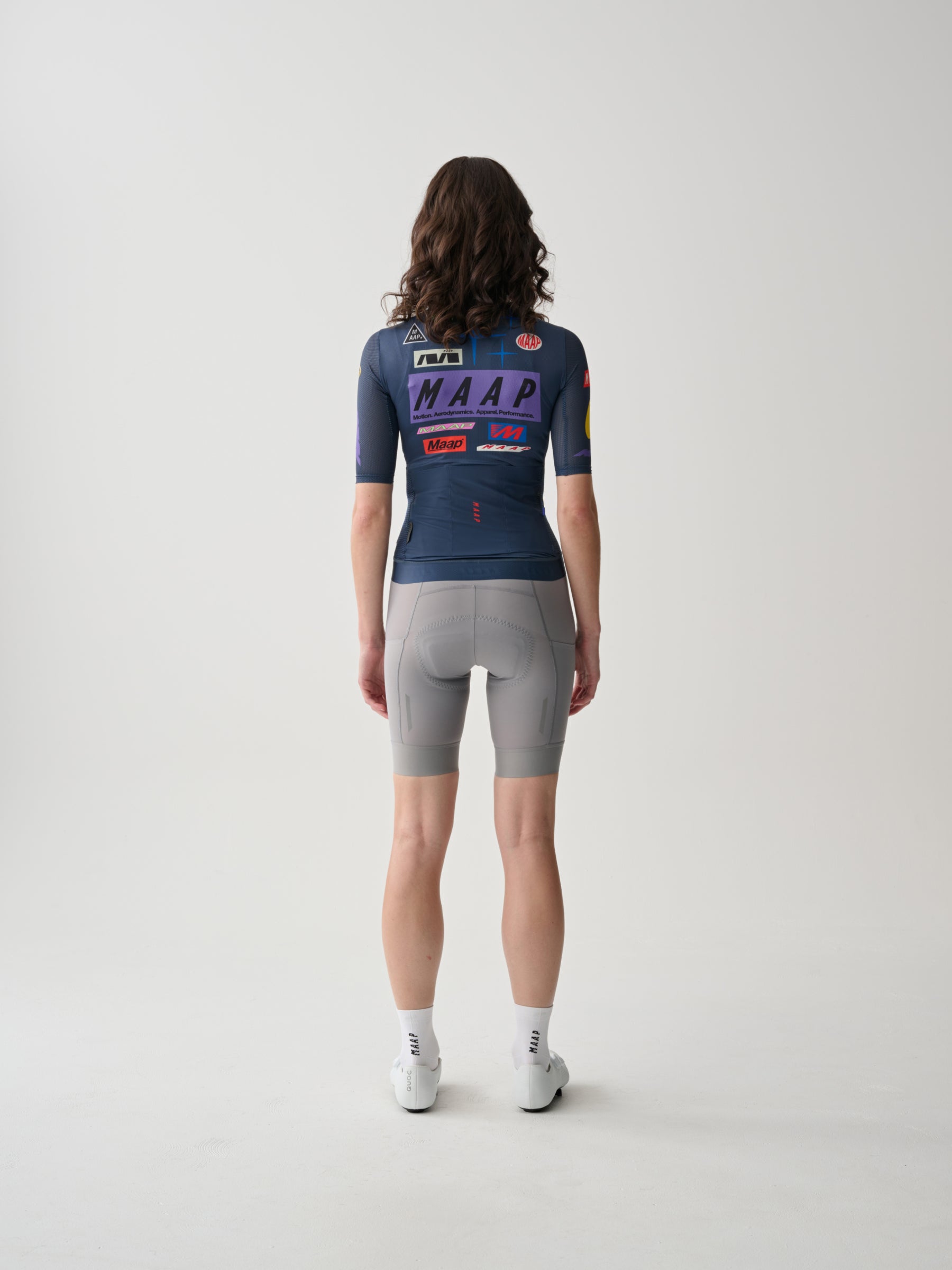 A female cyclist showing the back of a Women's MAAP Drome Short Sleeve Jersey in Midnight