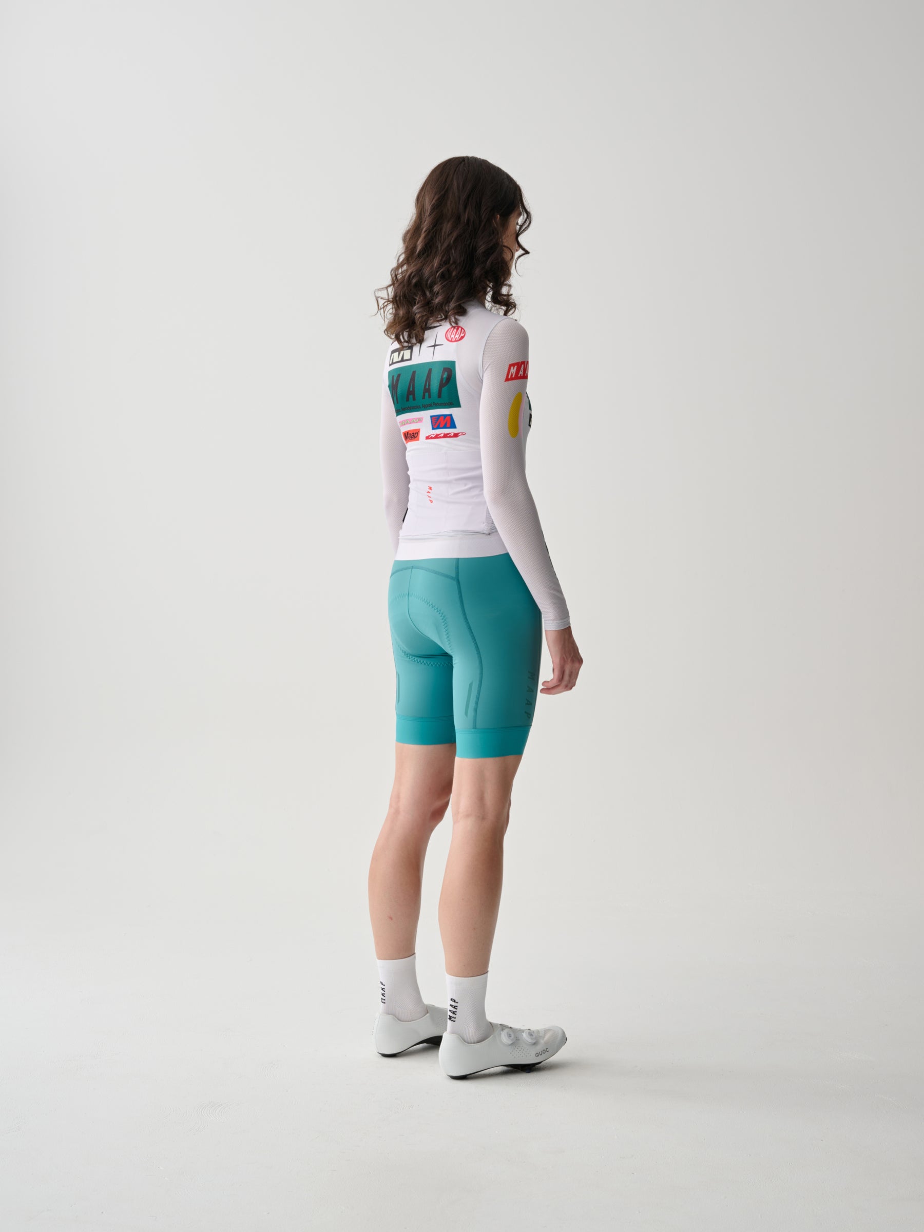 A female cyclist showing the back of a Women's MAAP Drome Long Sleeve Jersey in White