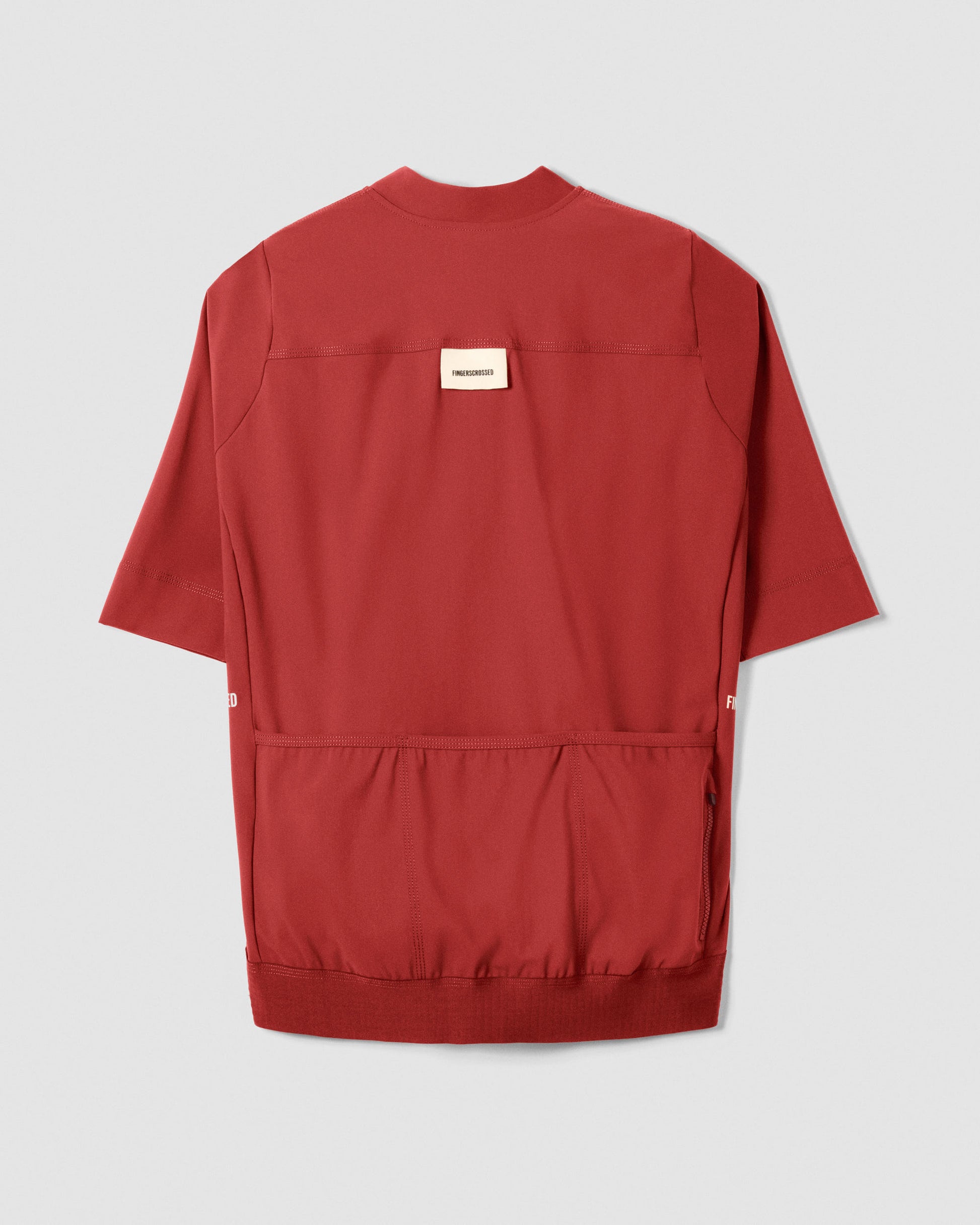 A Flat-lay image of the back of a Fingerscrossed #Road cycling jersey in Brick Red