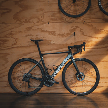 A Cervelo Soloist with Ultegra Di2 groupset leaning against a plywood wall in Metier Racing & Coffee in Seattle