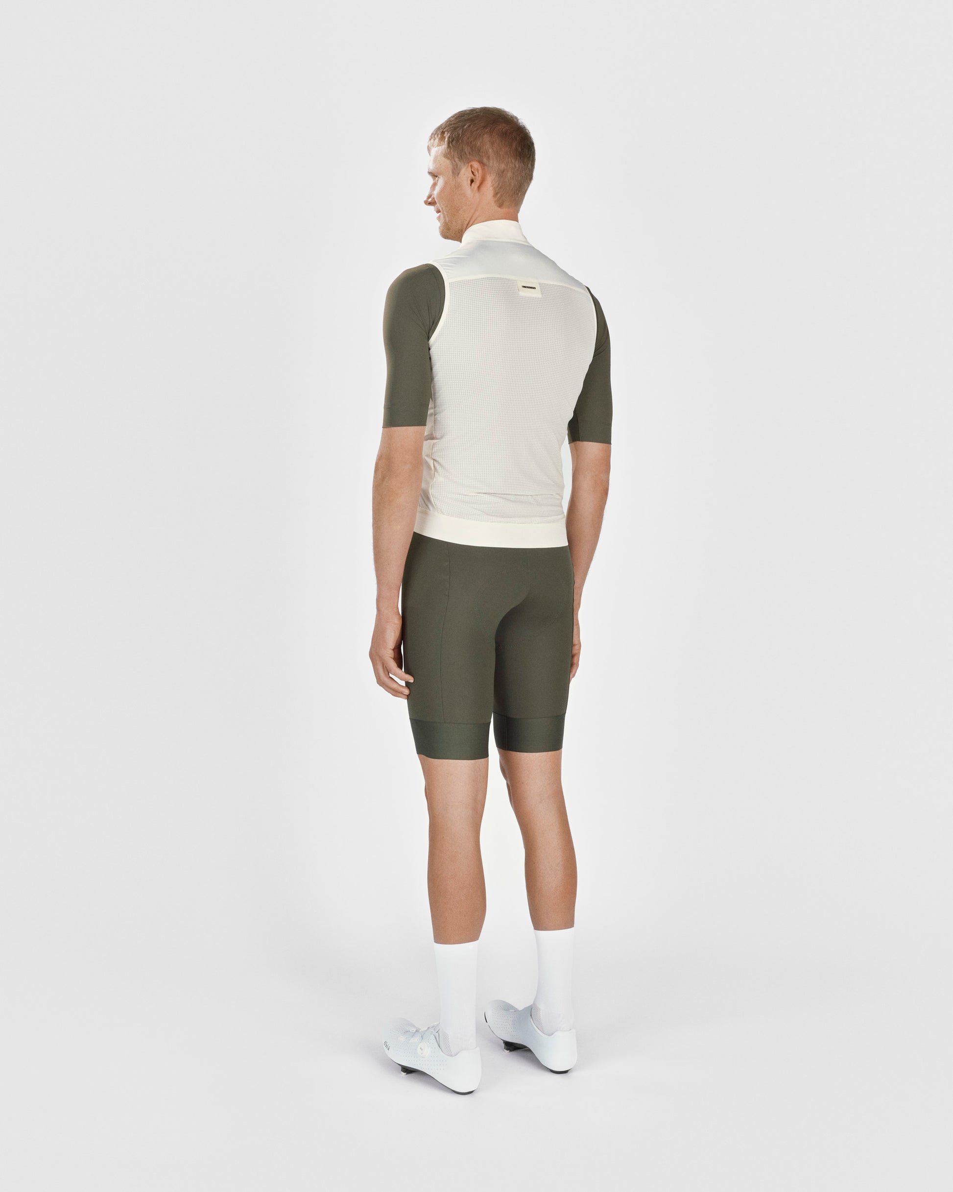 A male cyclist showing the back of a Fingerscrossed #Road cycling Vest in Cream