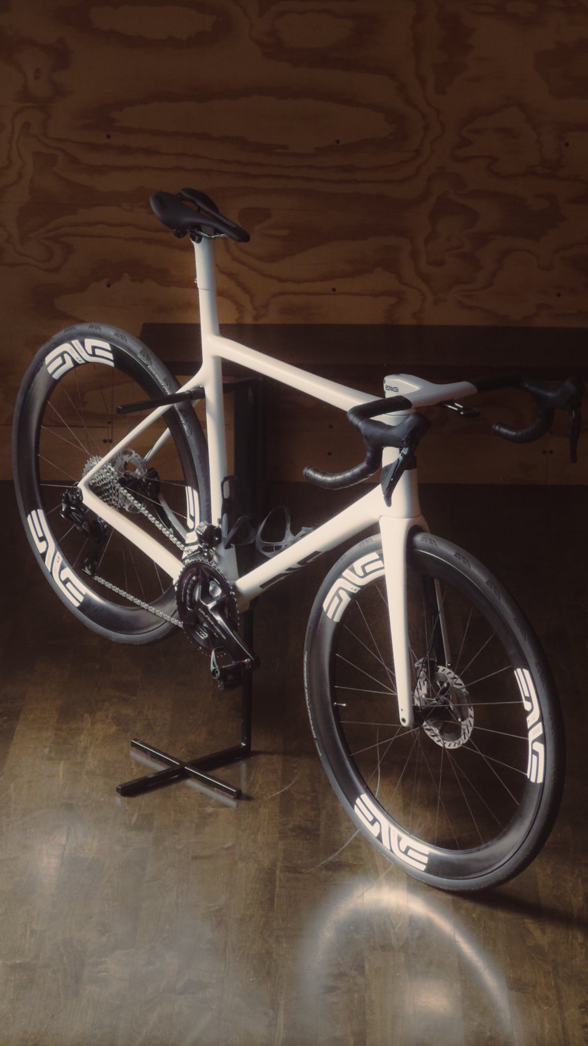 An Enve Custom Road bike in Aspen White on display in a plywood room at Metier.